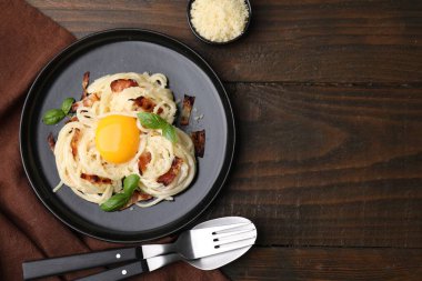 Carbonara makarnası ahşap masada servis ediliyor. Metin için boşluk