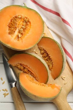 Olgun kavun ve beyaz ahşap masa üzerinde bıçak, düz yatıyordu.