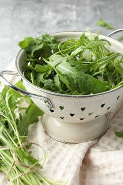 Taze yeşil roka yaprakları kevgir masasında.