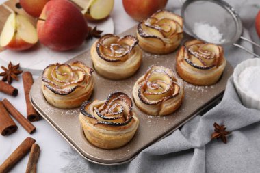 Taze pişmiş elma gülleri ve malzemeler beyaz masada. Puf böreği