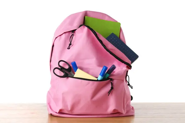 stock image Backpack with different school stationery on wooden table against white background