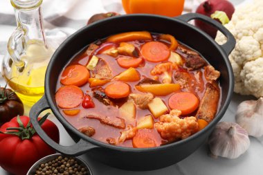 Tasty homemade stew with vegetables on white tiled table, closeup clipart