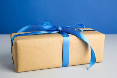 Arkaplanda mavi saten fiyonklu hediye kutusu, yakın plan