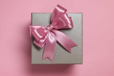Tozlu pembe arka planda fiyonklu hediye kutusu, üst manzara