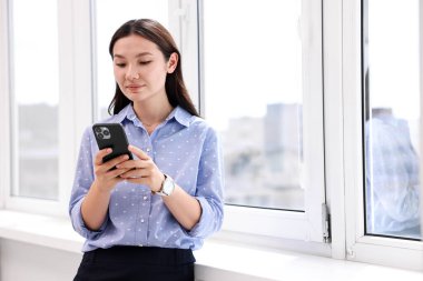 Ofisinde akıllı telefonu olan güzel bir iş kadını. Metin için boşluk