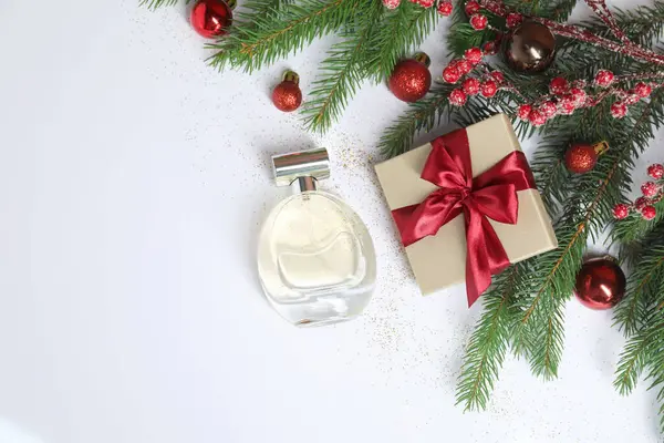 Beyaz arka planda parfüm şişesi olan Noel kompozisyonu. Metin için boşluk