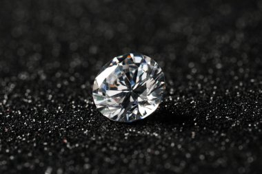 Beautiful dazzling diamond on dark shiny background, closeup clipart