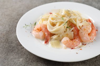 Gri masada karides ve peynirli lezzetli makarna, yakın plan.