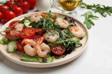 Lezzetli karides salatası ve malzemeler beyaz masada, yakın plan.