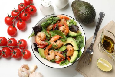 Lezzetli karides salatası ve malzemeler beyaz masada, düz yerde.