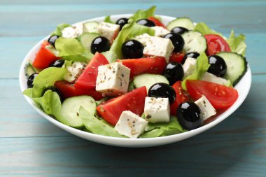 Açık mavi ahşap masada beyaz peynir ile nefis salata, yakın plan.