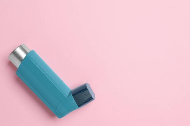 Pembe arka planda astım spreyi, üst görüş. Metin için boşluk