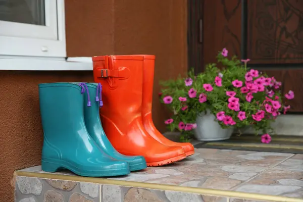 stock image Two pairs of rubber boots on doorstep near entrance outdoors