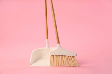 Pembe arka planda süpürge ve faraş temizleme