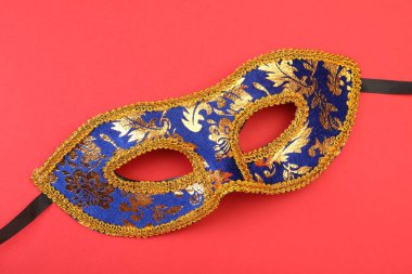 Kırmızı arka planda güzel bir karnaval maskesi.