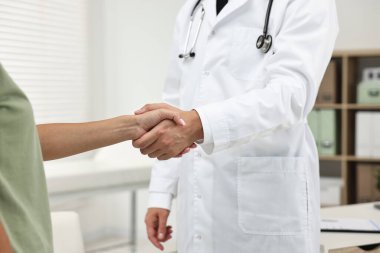 Hastanedeki hastayla el sıkışan doktor, yakın plan.