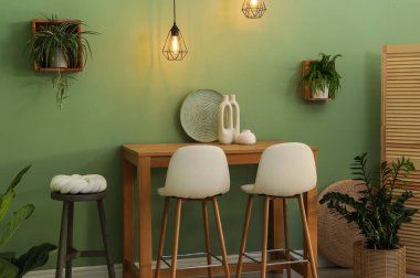 Bar tabureleri, masa ve bitkiler odada. Şık iç tasarım