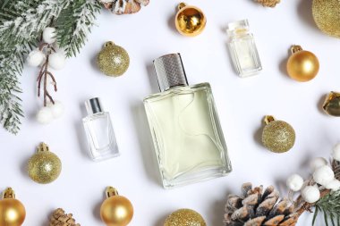 Beyaz arka planda parfüm şişeleri olan Noel kompozisyonu.