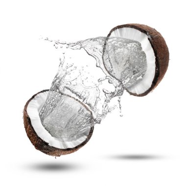 Taze hindistan cevizi suyu beyaz arka planda fındıktan sıçrıyor.