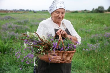 Tentür için kır çiçekleriyle kıdemli kadın.