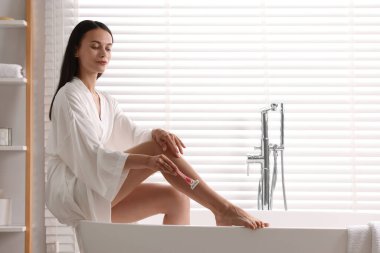 Banyoda bacağını tıraş eden güzel bir kadın. Sevk prosedürü
