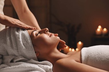 Çekici kadın spa salonunda yüz masajından hoşlanıyor, yakın plan.