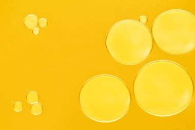 Koyu sarı arka planda kozmetik yağı örneği, makro görünüm
