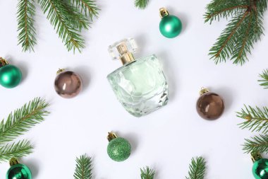 Beyaz arka planda parfüm şişesi olan Noel kompozisyonu.