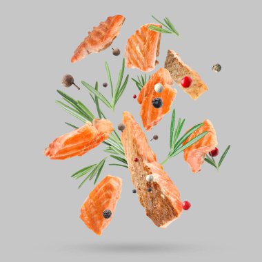 Lezzetli ızgara somon, biberiye ve arkaplana düşen biber karışımı.