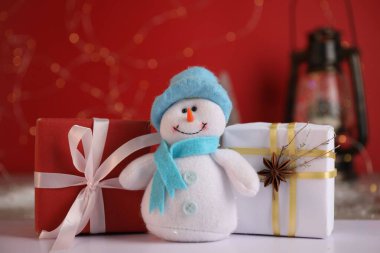 Komik kardan adam figürü ve beyaz masada Noel hediyeleri