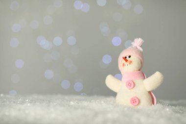 Bulanık ışıklara karşı yapay kar üzerinde sevimli bir kardan adam. Metin için boşluk