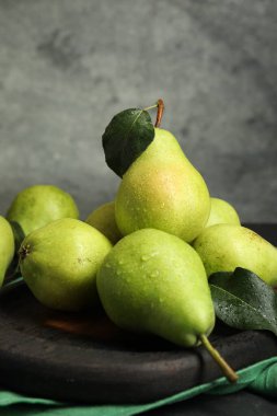 Masada taze armut ve yeşil yapraklar var. Yakın plan.