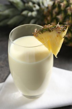 Bardakta lezzetli ananas püresi ve masada taze meyve, yakın plan.