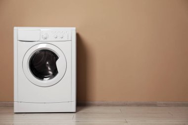 Bej duvarın yanında çamaşır makinesi, metin için boşluk