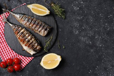 Lezzetli ızgara uskumru, kekik, limon ve domatesler koyu dokulu masa, düz yatak. Metin için boşluk