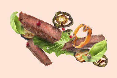 Bej arka planda ızgara et ve sebze.