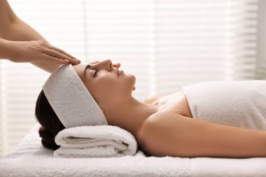 Çekici kadın spa salonunda yüz masajından hoşlanıyor.