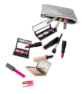 Beyaz arka planda gümüş kozmetik çantadan düşen farklı makyaj ürünleri