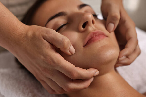Attractive woman enjoying face massage, closeup. Beauty procedure