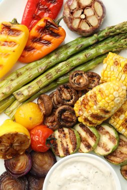 Beyaz masada soslu leziz ızgara sebzeler.