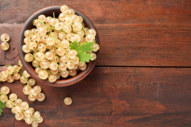Kasede taze kuşüzümü ve ahşap masada yeşil yaprak, üst manzara. Metin için boşluk
