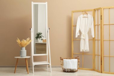 Banyoda bej duvarın yanında büyük bir ayna var. İç tasarım