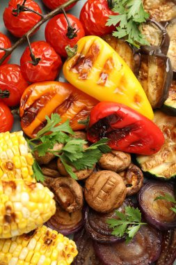 Lezzetli ızgara sebzeler masada, düz yerde.