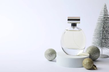 Beyaz arka planda parfüm şişesi ve Noel dekorunun şık kompozisyonu. Metin için boşluk