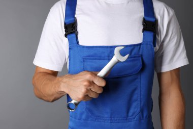 Gri arkaplanda ingiliz anahtarı olan oto tamircisi, kapat