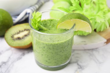Lezzetli yeşil smoothie limon ve beyaz mermer masa üzerinde ürünler, yakın çekim