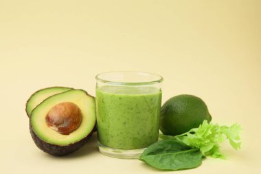 Lezzetli yeşil smoothie cam ve bej arka planda ürünler