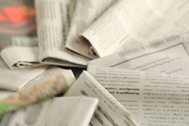 Arka plan olarak farklı dillerde birçok gazete, yakın plan