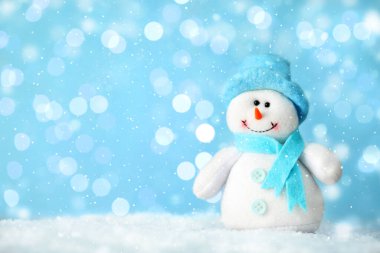 Tatlı kardan adam açık mavi arka plana karşı bulanık Noel ışıkları, bokeh etkisi. Metin için boşluk