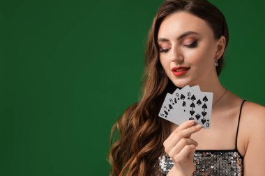 Poker oyunu. Yeşil arka planda oyun kartları olan çekici bir kadın. Metin için boşluk